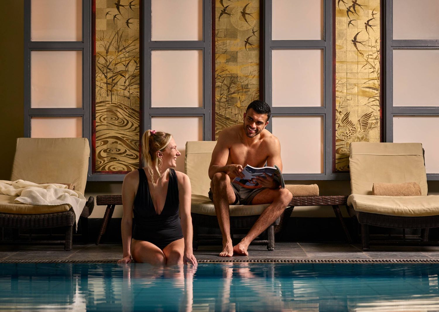 Couple sitting poolside