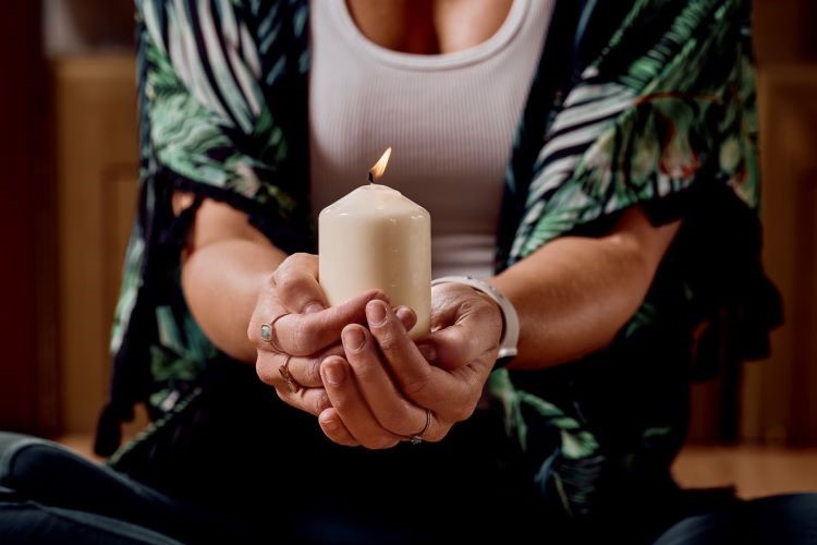 Lit candle in the hands of a lady